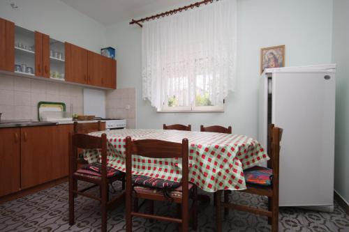 Il comprend une cuisine équipée d'une table, de chaises et d'un réfrigérateur. dans l'établissement Apartments with a parking space Sukosan, Zadar - 6332, à Sukošan