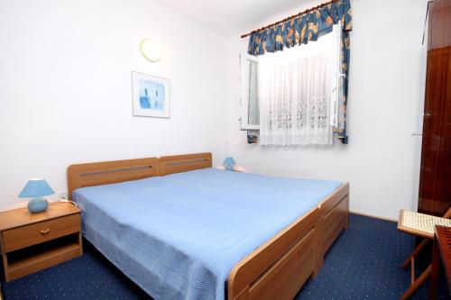 ein kleines Schlafzimmer mit einem Bett und einem Fenster in der Unterkunft Apartments by the sea Brgulje, Molat - 6243 in Molat