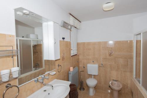 a bathroom with a sink and a toilet and a mirror at Apartments with a parking space Molat - 6249 in Molat