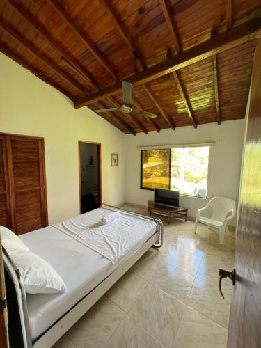 a bedroom with a bed and a tv in it at Finca en Doradal ( Hacienda Napoles y Rio Claro ) in Doradal