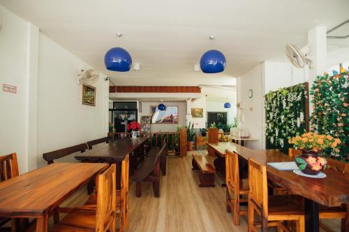 uma sala de jantar com mesas e cadeiras de madeira em Nu Phen Homestay em Chiang Mai