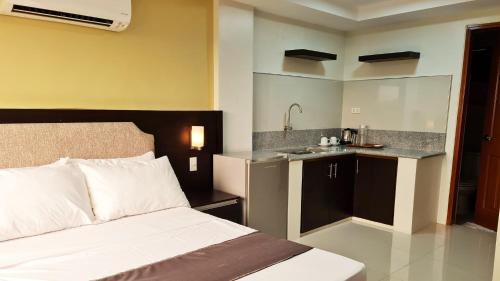 ein Hotelzimmer mit einem Bett und einer Küche in der Unterkunft Staycation Hotel 