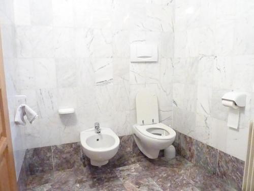 uma casa de banho branca com um WC e um bidé em Appartamento Stumiaga di Fiavè em Fiavè