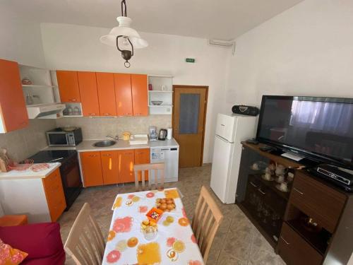 eine kleine Küche mit einem Tisch und einem TV in der Unterkunft Apartments by the sea Postira, Brac - 14902 in Postira