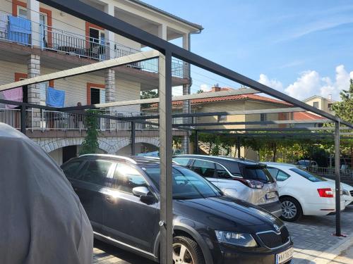 a carport with cars parked in a parking lot at Triple Room Selce 2379d in Selce
