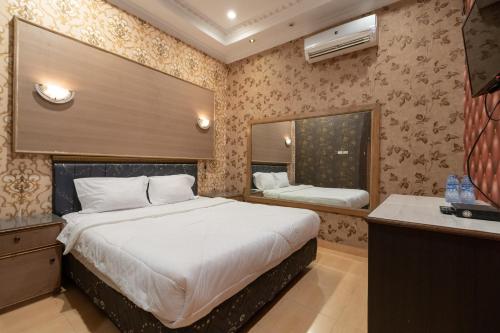 a bedroom with a large bed and a sink at Urbanview Hotel Good Palembang by RedDoorz in Talang Kelapa