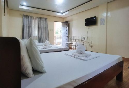 a bedroom with two beds with towels on them at RedDoorz @ Los Ecijanos Inn Pangasinan in Bolinao