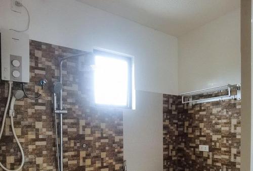 bagno con doccia e finestra sul muro di RedDoorz @ Los Ecijanos Inn Pangasinan a Bolinao