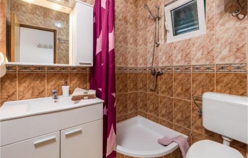 een badkamer met een wastafel en een spiegel bij 2 Bedroom Beautiful Apartment In Stara Novalja in Stara Novalja
