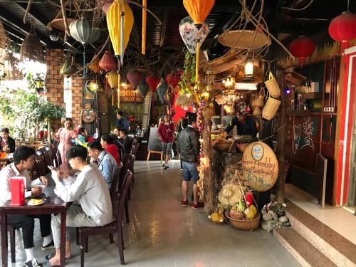 un gruppo di persone seduti ai tavoli in un ristorante di Redhouse Dalat Hotel a Da Lat