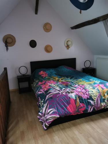 een slaapkamer met een bed met een kleurrijk dekbed bij La Maison d'Yvonne in La Bouille