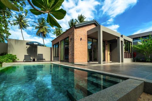 a swimming pool in front of a house at Thai Fight Hotel in Lamai
