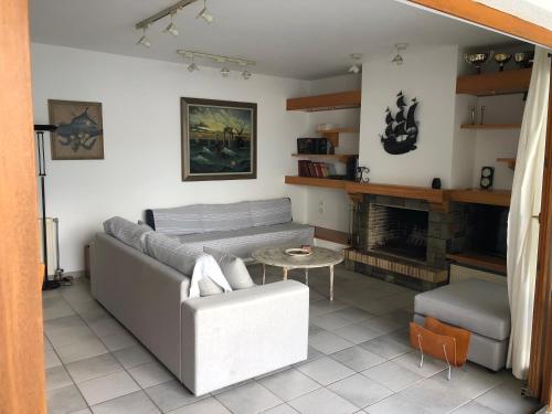 a living room with a couch and a fireplace at Sea-side 3 BEDROOM- BEACH HOUSE in Poros
