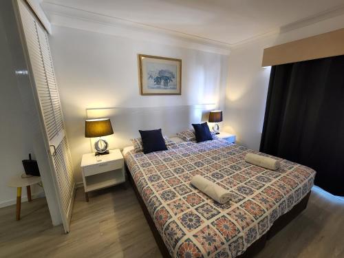 sypialnia z łóżkiem i nocną szafką z lampką w obiekcie PERTH CBD APARTMENTS w mieście Perth
