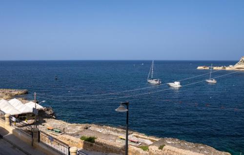 a view of the ocean with boats in the water at Sea-view Apartment in Marsalforn in Marsalforn