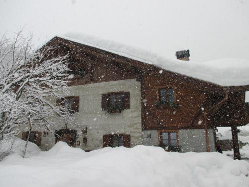 a house with snow on the roof of it at Maso Pin in Madonna di Campiglio
