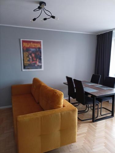 a living room with a couch and a dining room table at Apartament Sucharskiego in Gdynia