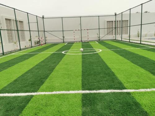 an empty soccer field with a soccer ball on it at VENESIA chalet in Al Kāmil