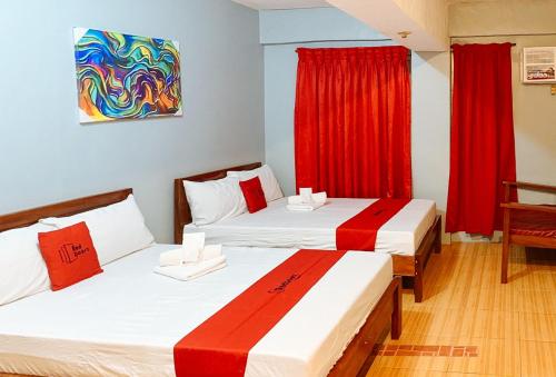 two beds in a room with red curtains at RedDoorz near Pasay Rotonda in Manila
