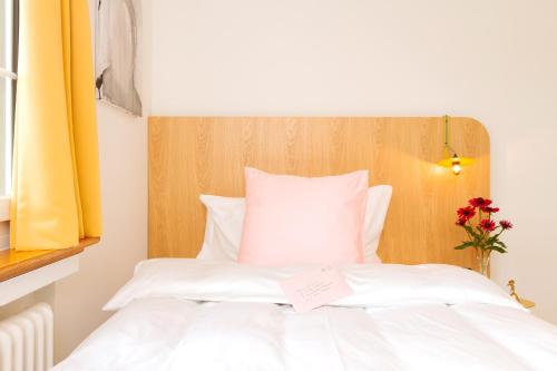 a bedroom with a white bed with a wooden headboard at Villa Maria in Luzern