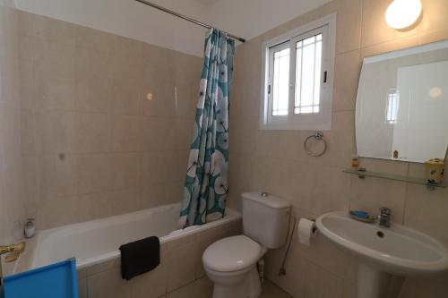 ein Badezimmer mit Toilette, Waschbecken und Spiegel in der Unterkunft Apartment in Kato Pafos & 10 min to Venus beach in Paphos City