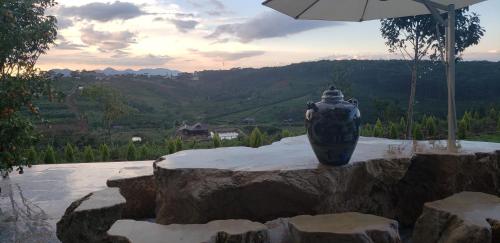 a vase sitting on top of a stone wall at KAZUO Village in Bao Loc