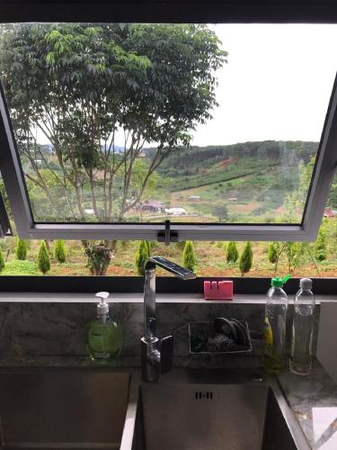 a kitchen sink with a view of a tree at KAZUO Village in Bao Loc