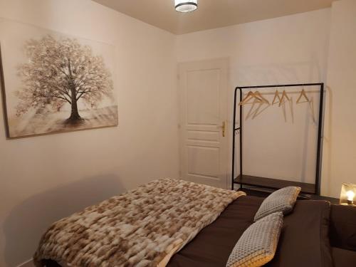a bedroom with a bed and a tree on the wall at Georges, un appartement au look chic rustique in Saint-Georges-sur-Baulche