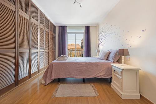 勞羅塔瓦的住宿－Atico Mencey，一间卧室设有一张大床和一个窗户。
