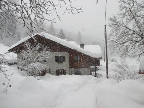 a house covered in snow with a pile of snow at Maso Pin in Madonna di Campiglio