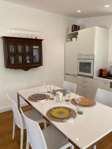 a kitchen with a white table with plates on it at Villa mare Fontane Bianche in Fontane Bianche