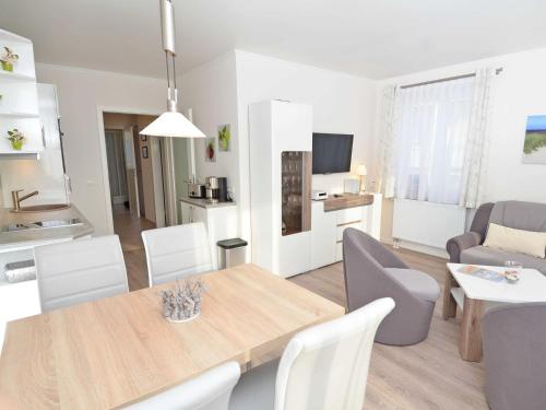 a dining room and living room with a table and chairs at Wohnpark Stadt Hamburg - Apt. 09 in Binz