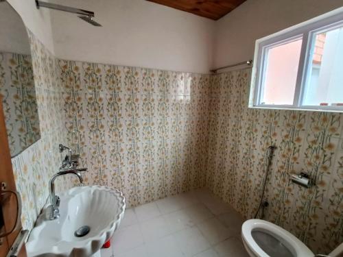 ein Bad mit einem Waschbecken und einem WC in der Unterkunft Kolahoi Heights Guest House in Pahalgām