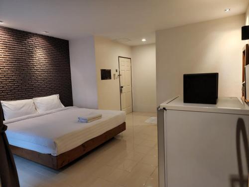 a bedroom with a bed and a tv on a counter at Dfeel House in Patong Beach