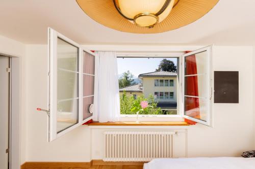 Schlafzimmer mit einem Fenster mit Blick auf ein Gebäude in der Unterkunft Villa Maria in Luzern