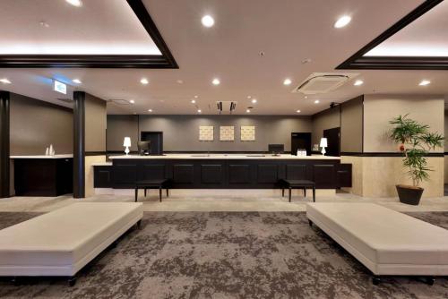 a large lobby with two white couches in a room at Minamisenri Crystal Hotel in Suita