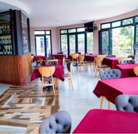 a dining room with tables and chairs and pink tables at Home Free Hotel in Kigali