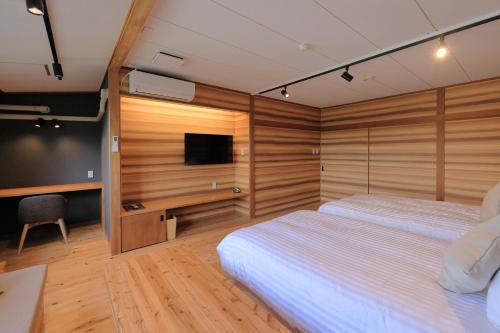 a bedroom with two beds and a flat screen tv at mt. inn(マウントイン） in Nihommatsu