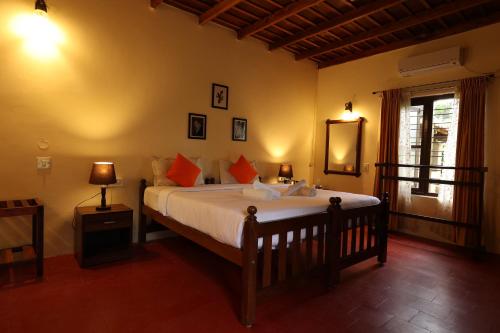 a bedroom with a large bed and a window at Avadale Coorg - Stag Groups Not Allowed in Ammatti