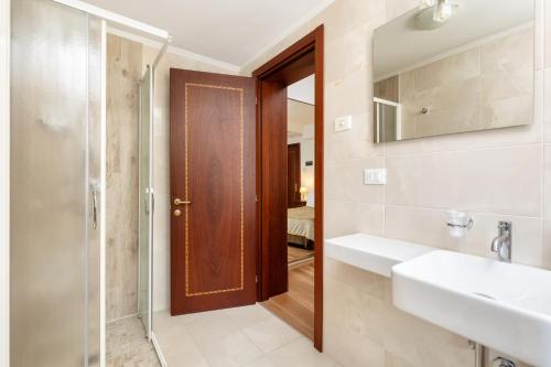a bathroom with a shower and a sink and a mirror at Hotel Giardinetto Venezia in Venice-Lido