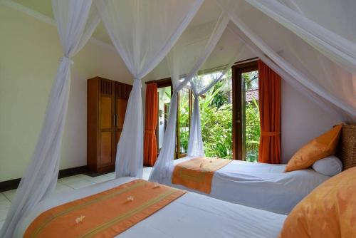 BuktiにあるVilla Kupu Kupuのベッド2台と窓のある寝室