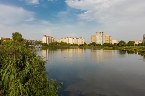 een groot meer met gebouwen op de achtergrond bij Lakeview Apartment Kapelanów Armii Krajowej by Renters in Warschau