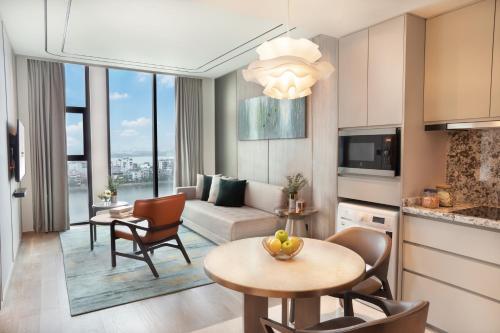 a living room with a couch and a table and chairs at Fraser Suites Hanoi in Hanoi