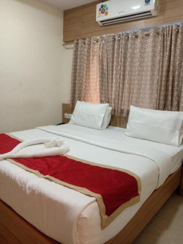 a hotel room with two beds and a window at Hotel Blue Bell in Bengaluru