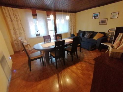 APARTMA ŽELE في بوستوينا: غرفة معيشة مع طاولة وكراسي وأريكة