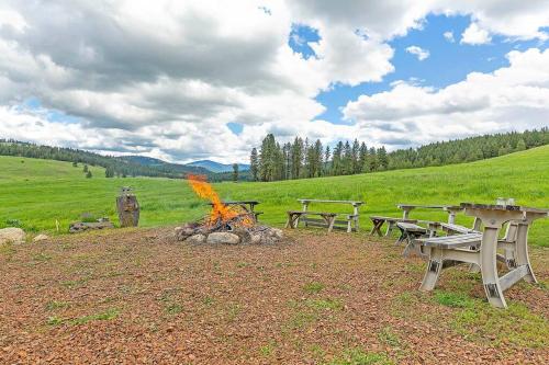 a group of picnic tables and a fire in a field at Eagle's Roost Cabin - Eden Valley in Oroville