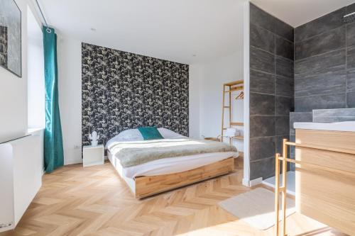 - une chambre avec un lit et un mur noir dans l'établissement Le Longeville, à Longeville-lès-Metz