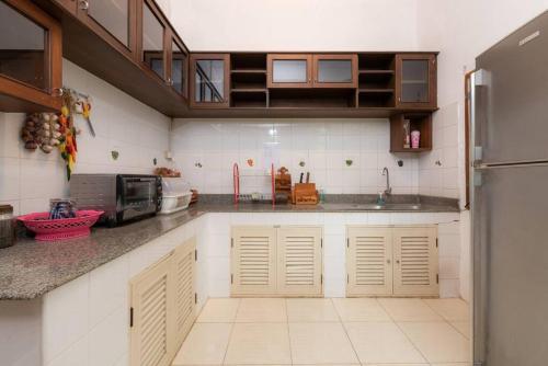 a kitchen with white cabinets and a counter top at Rosathorn Homestay San Kamphaeng in Ban Mae Pu Kha