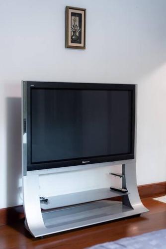 a flat screen tv sitting on a tv stand at Rosathorn Homestay San Kamphaeng in Ban Mae Pu Kha