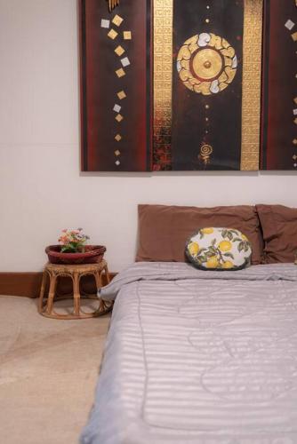a bedroom with a bed and a table with a bed sidx sidx sidx at Rosathorn Homestay San Kamphaeng in Ban Mae Pu Kha